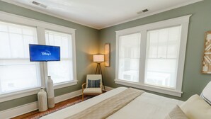 A hotel room with a bed, a chair, a lamp, and a television. - Historic Revival Midtown Memphis Free Parking (Memphis)
