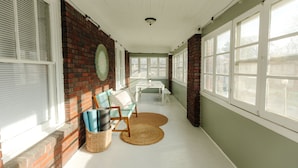 A sunlit room with a brick wall, a white ceiling, and large windows. - Historic Revival Midtown Memphis Free Parking (Memphis)