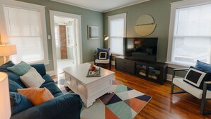 A living room with a sofa, coffee table, TV, and a patterned rug. - Historic Revival Midtown Memphis Free Parking (Memphis)