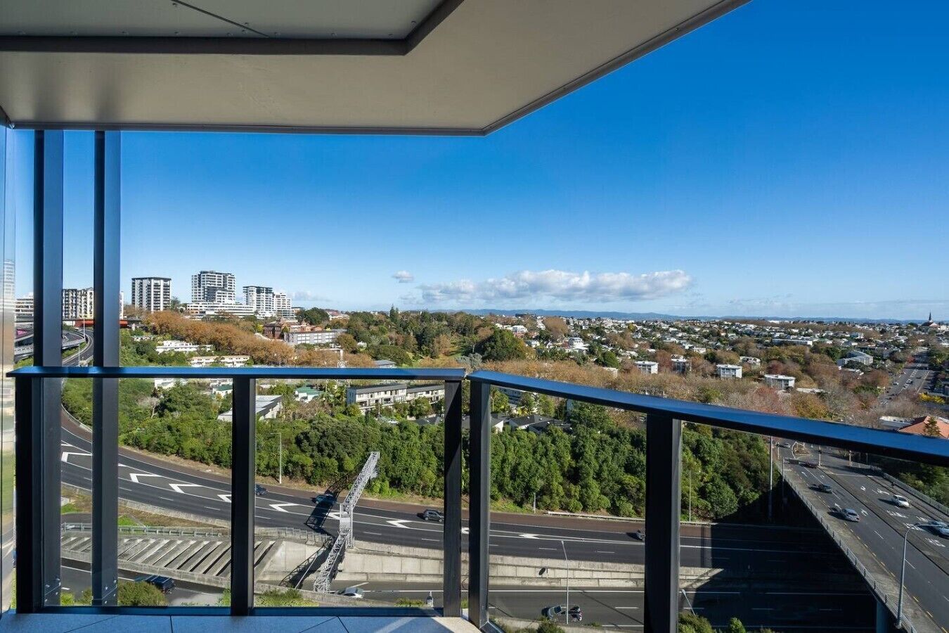 Un edificio de gran altura con vistas a un paisaje urbano, incluyendo calles y zonas verdes.