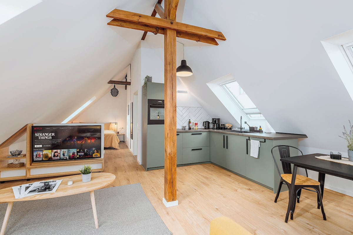 A modern loft apartment with a kitchen, dining area, and living space.