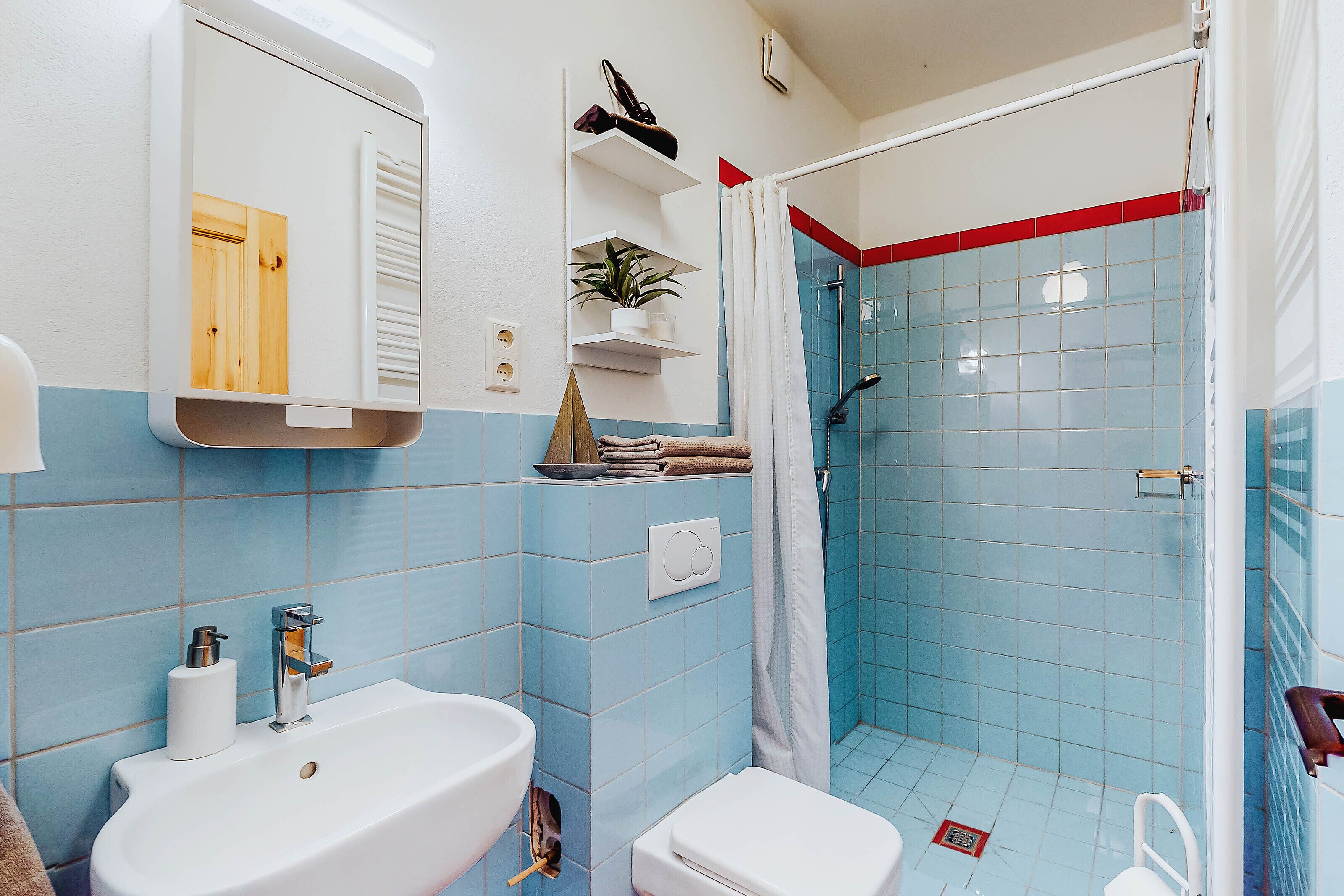Ein Badezimmer mit Waschbecken, Toilette und Duschbereich.