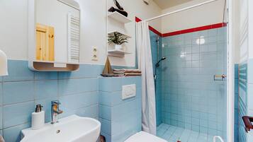 Ein Badezimmer mit Waschbecken, Toilette und Duschbereich.