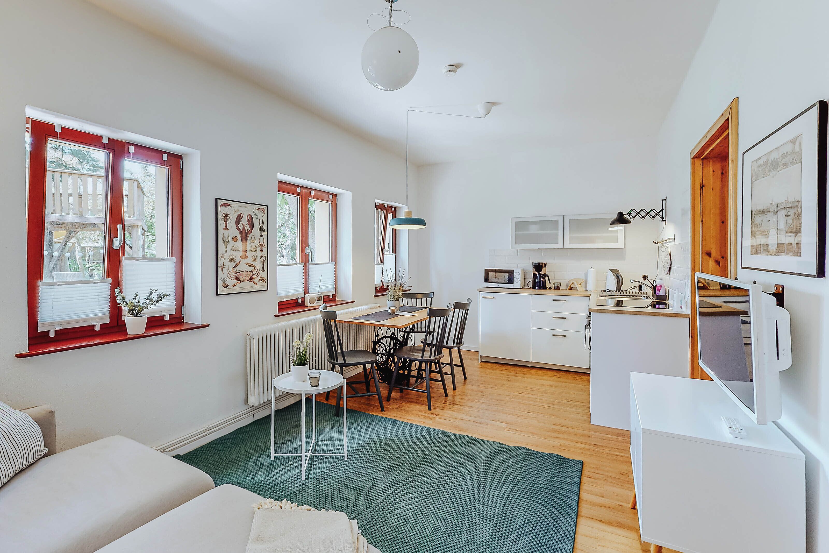 Un espace de vie compact comprenant un coin repas, une kitchenette et un coin salon confortable.