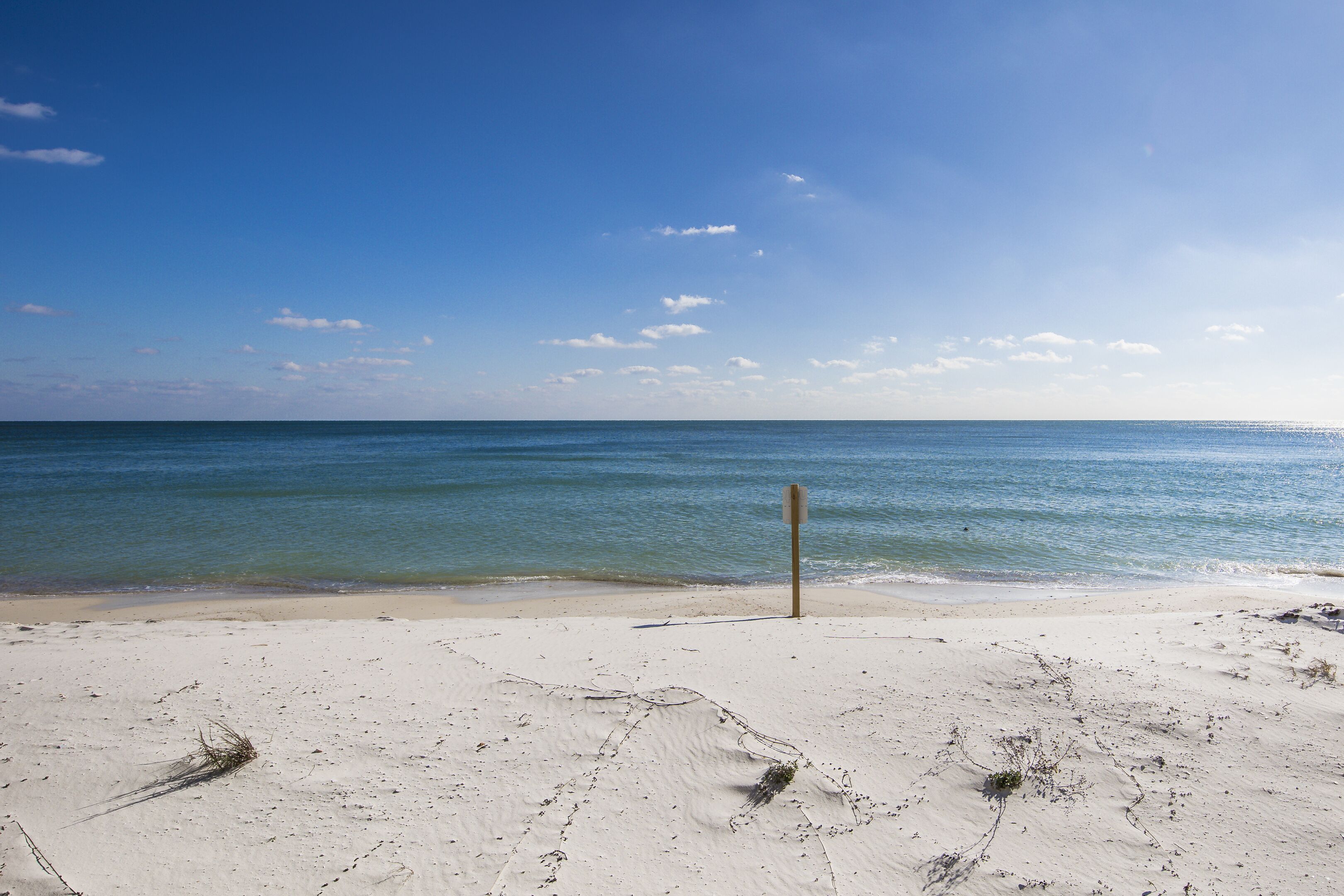 Ein Strand mit klarem, blauem Wasser und einem Sandufer.