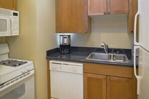 Efficient kitchen with stove, microwave, dishwasher, coffee maker, and refrigerator.
