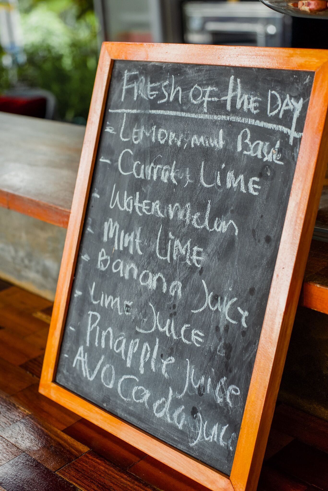A chalkboard menu listing fresh fruits and juices.