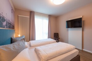 Relax in this stylish room with a large bed, flat-screen TV, and a cozy reading nook by the window.