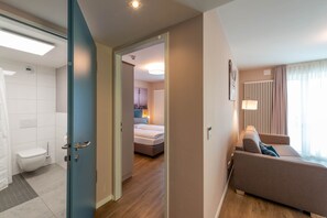 Relax in a spacious room with a large bed, sofa, and city views.