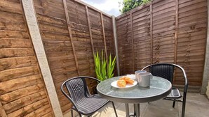 A patio with a round table, two chairs, a plate with croissants, and two mugs. - ⭐️Oxford⭐️ modern stylish apartment patio & parking (Oxford)