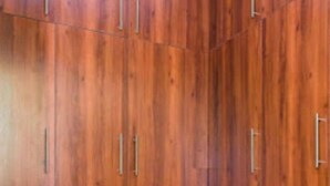 A corner of a room with wooden cabinets and metal handles. - Loumia Residency 3ch (Douala)