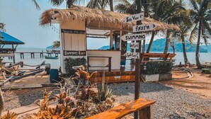 A beach bar with a thatched roof, a sign for 'Sea View Bar', and a wooden bench. - Banmae Resort Kohchang (Ko Chang)