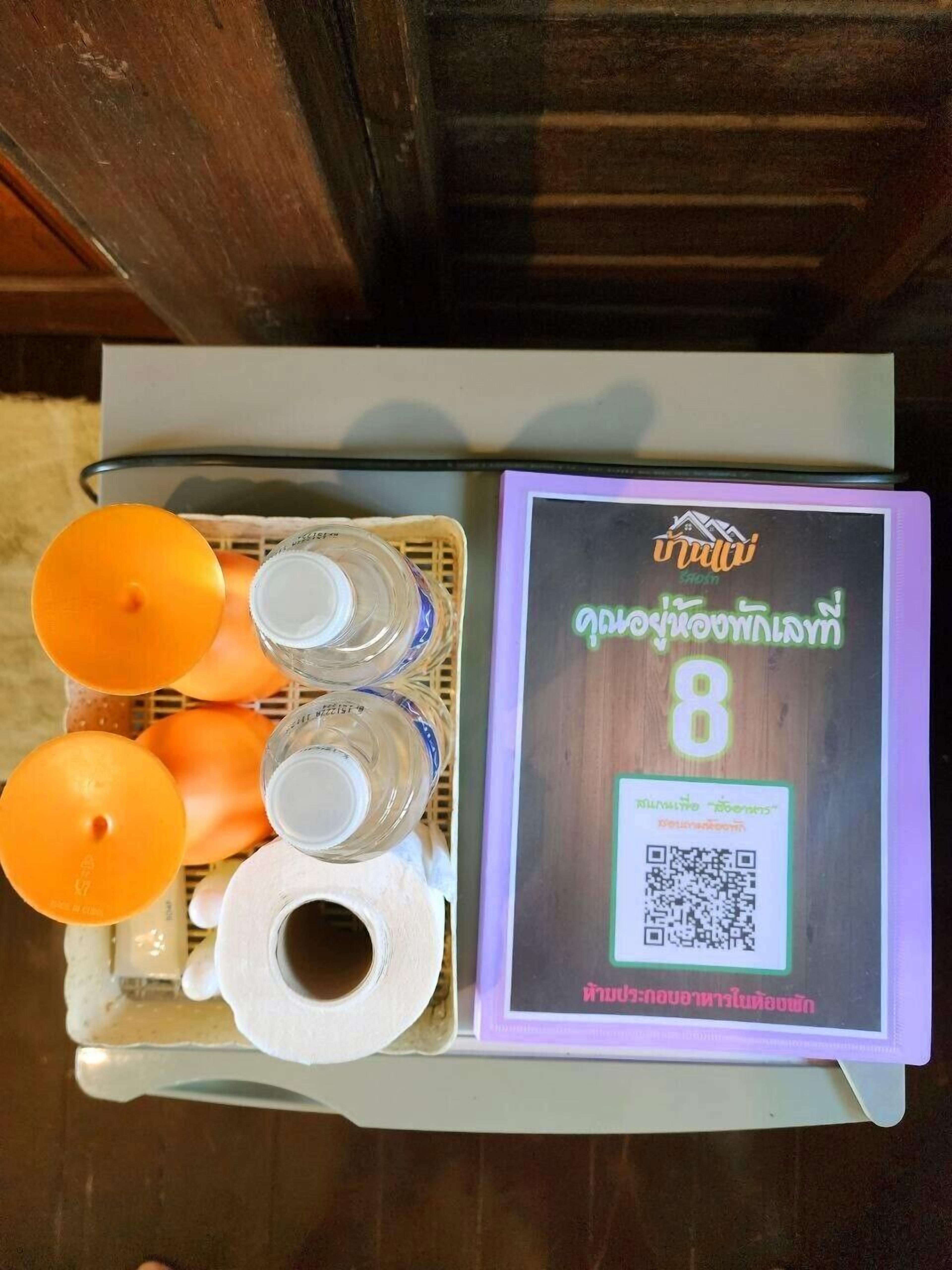 Ein Tablett mit Wasserflaschen, Orangen und einer Toilettenpapierrolle.