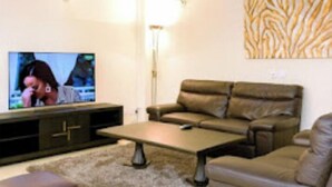 A living room with a sofa, a coffee table, and a television.