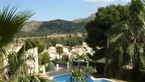 A pool surrounded by palm trees and a view of a town with white buildings and a mountain in the background. - Green I - 4A (Pedreguer)