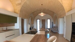 Una cocina moderna con una isla, un área de comedor con un sofá y un horno empotrado.