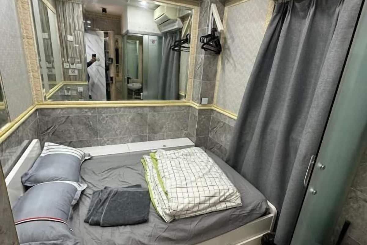 Relax in this stylish room featuring a comfortable bed, large mirror, and convenient seating area.