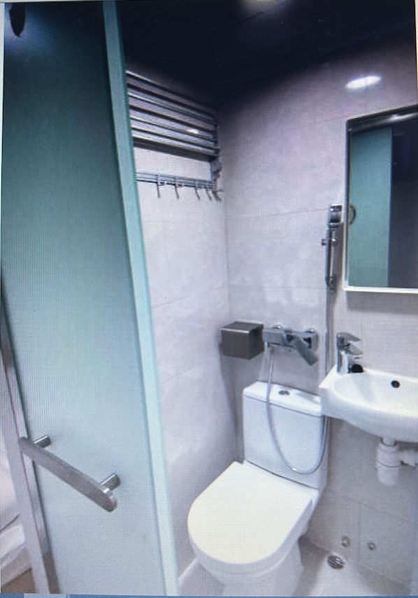 Un baño pequeño con inodoro, lavamanos y espejo.
