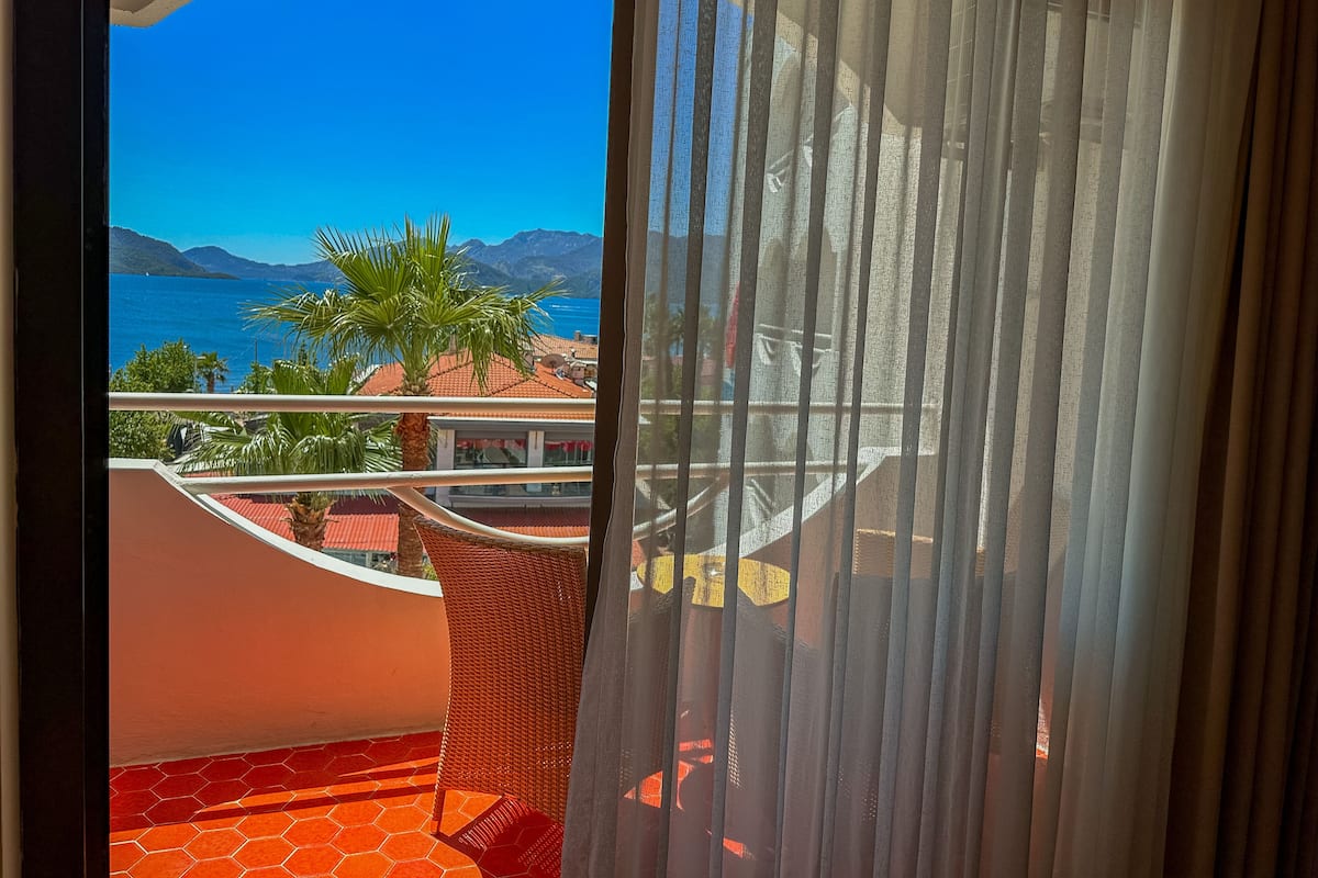 A balcony with a view of the sea and mountains.