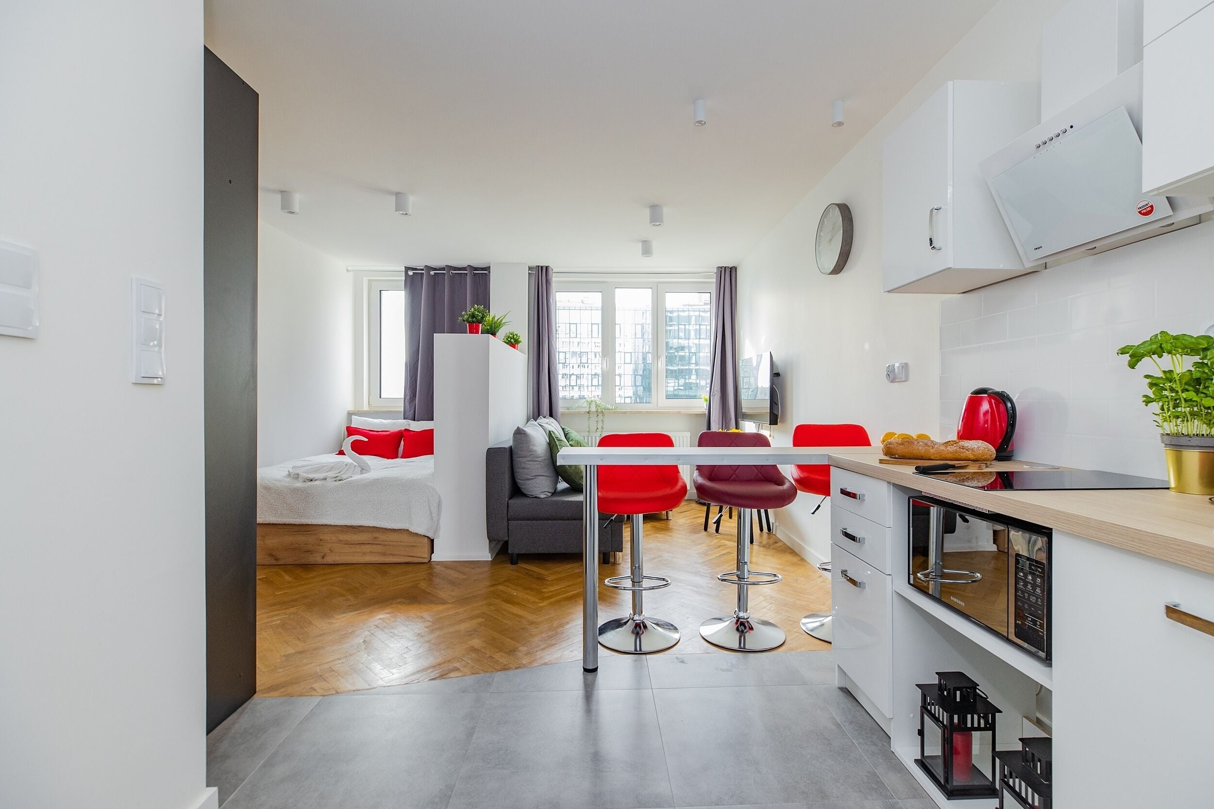 Eine moderne Küche mit Essbereich, einer Couch und Blick auf die Stadt.