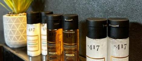 Una estantería con varios productos para el cuidado del cabello, incluyendo dos botellas etiquetadas con el número 417, una pequeña planta en maceta y un adorno.