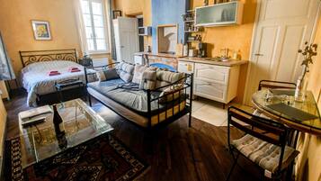Une chambre à coucher de taille réduite, comprenant un lit, des tables de chevet, un petit bureau et une chaise.