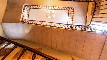 A staircase with a metal railing and a wall-mounted light fixture.