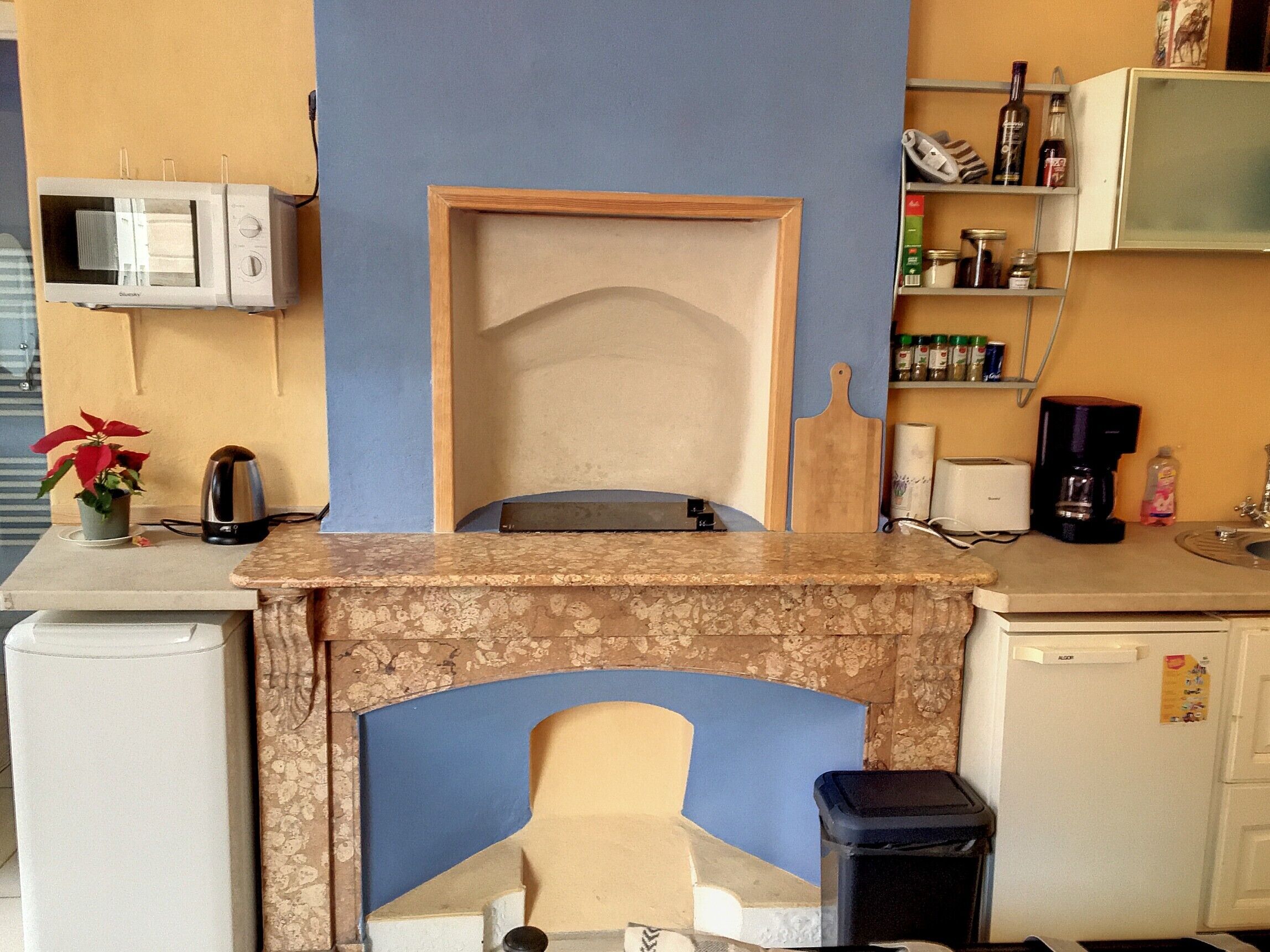 A kitchen with a microwave, a coffee maker, a toaster, and a sink.