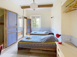 Una habitación con dos camas, una lámpara roja y una ventana.