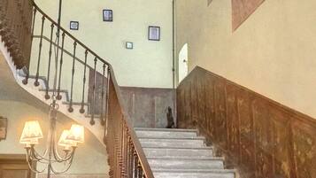 A grand staircase with ornate railings and a chandelier.