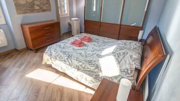 Ein Schlafzimmer mit einem Bett, einem Holzschrank und einem Nachttisch mit Lampe.