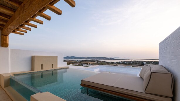 A rooftop infinity pool with a white infinity wall, a beige sofa, and a wooden pergola. - Utopia Suites by Anna Platanou - Adults only (Paros)