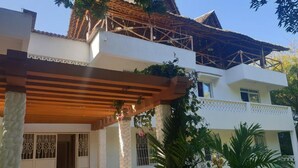 Een tweelaags huis met een overdekte patio en een balkon.