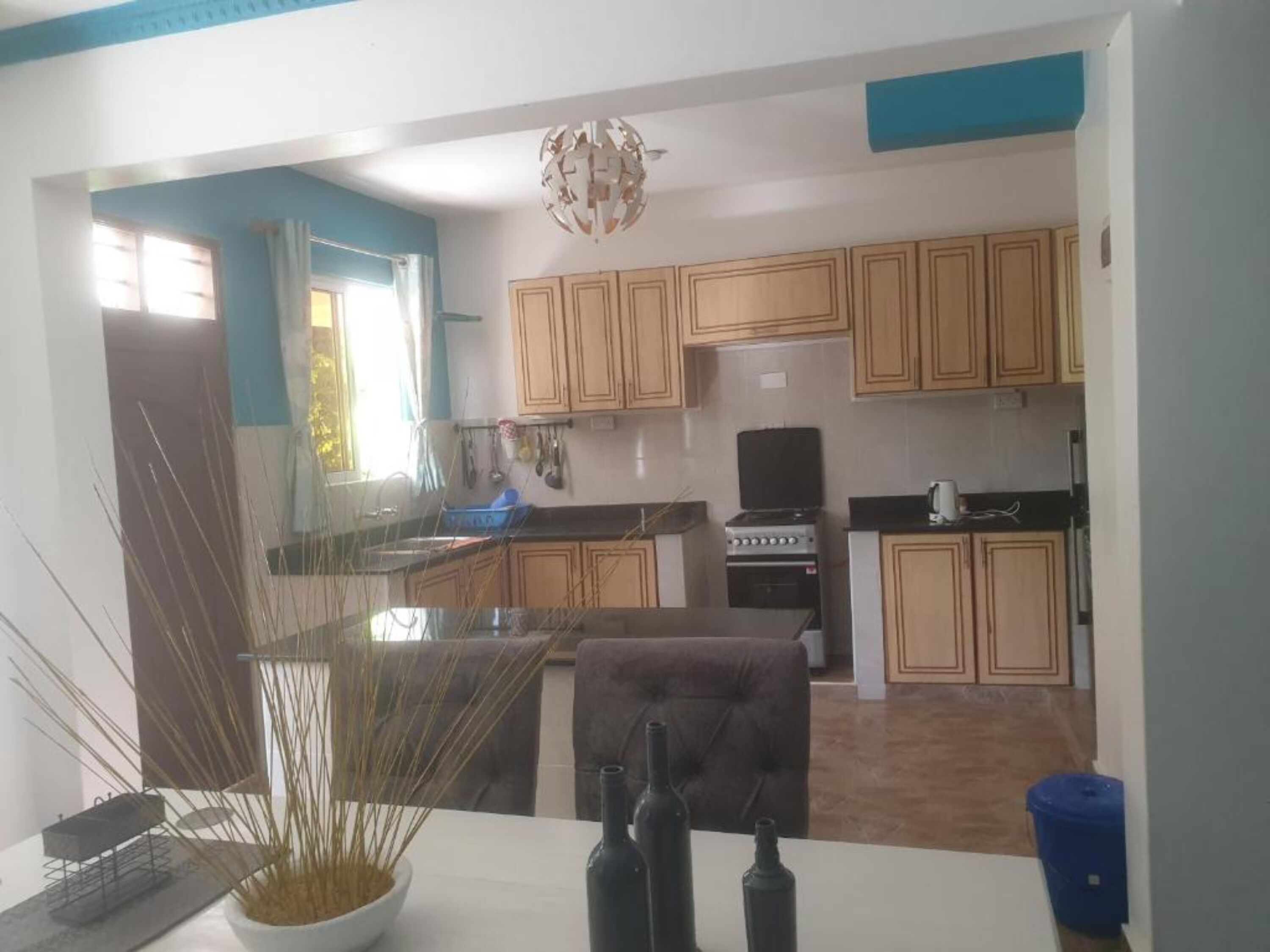 A kitchen with wooden cabinets, a stove, and a sink.