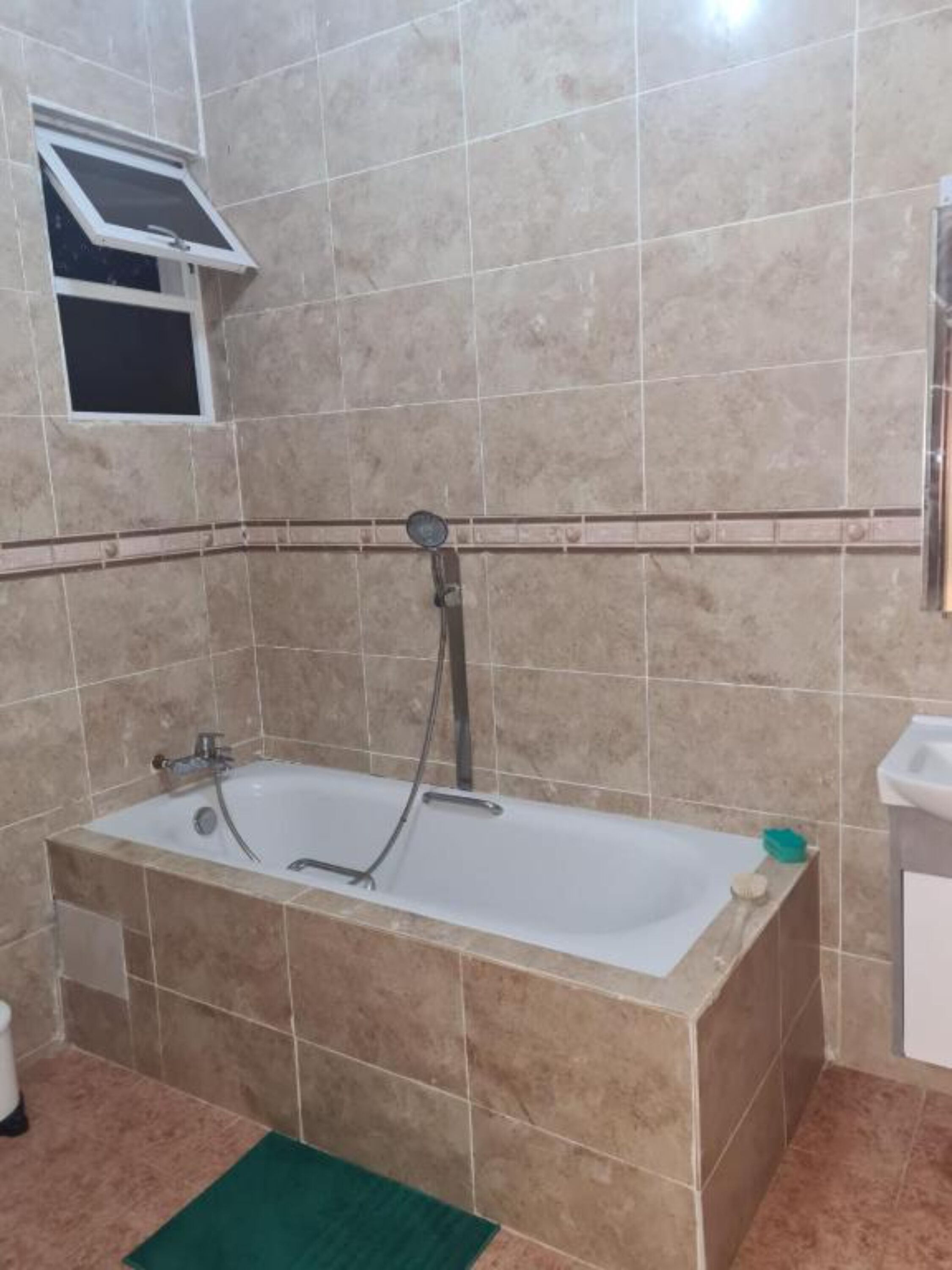 Un baño con bañera, ducha y lavabo.