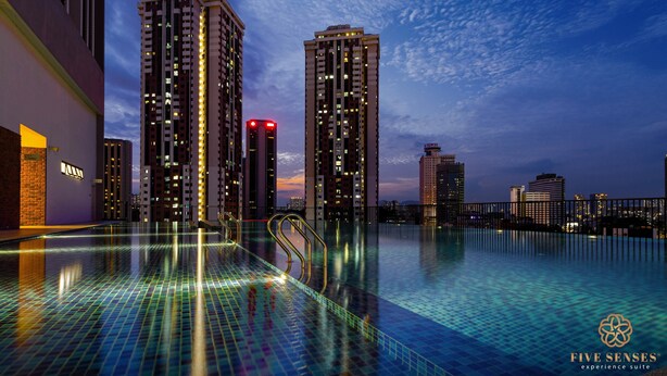 Una piscina a sfioro sul tetto con lo skyline della città sullo sfondo.