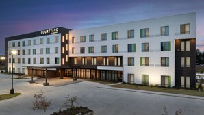 Courtyard by Marriott -hotelli, jossa on moderni muotoilu, useita kerroksia, suuret ikkunat ja tilava sisäänkäyntialue.