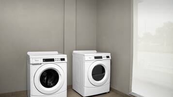 Two white Whirlpool front-loading washing machines in a corner of a room with a large window.