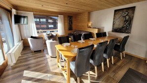 A wooden-paneled room with a dining table set for six, surrounded by chairs.