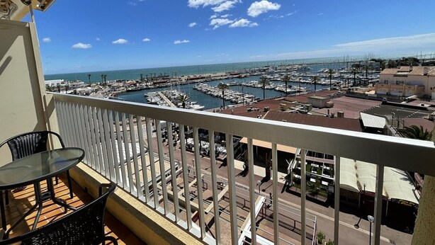 A balcony with a view of a marina and the sea. - Charming air-conditioned studio with wifi and parking 100m from the beach (Saint-Cyprien)