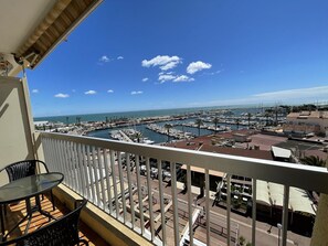 Un balcón con vistas a un puerto deportivo y al mar.