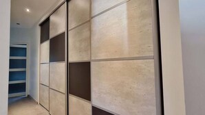 A hallway with a sliding door closet and a built-in shelf unit. - Welcome au Carpe Diem (Châteauneuf-du-Pape)