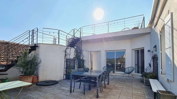 A rooftop patio with a table and chairs, a spiral staircase, and potted plants. - Welcome au Carpe Diem (Châteauneuf-du-Pape)