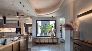 A modern interior with a kitchen, dining area, and seating space. - Ardor Exclusive Villas (Santorini)