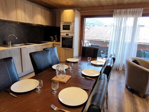 Enjoy meals in this stylish dining area with a wooden table, island, and matching chairs.