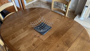 Pyöreä puinen pöytä, jonka päällä on metallinen ritiläteline.