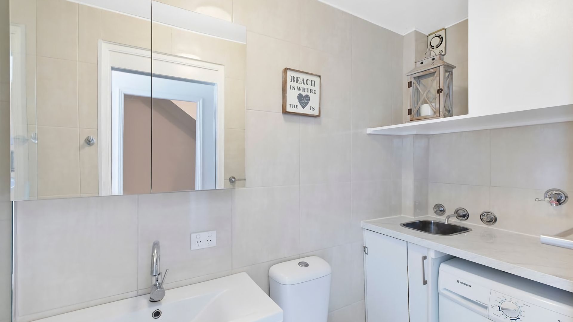 Un baño moderno con bañera, lavamanos, inodoro y espejo.