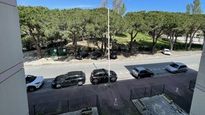 A parking area with several cars, a clear sky, and trees in the background.