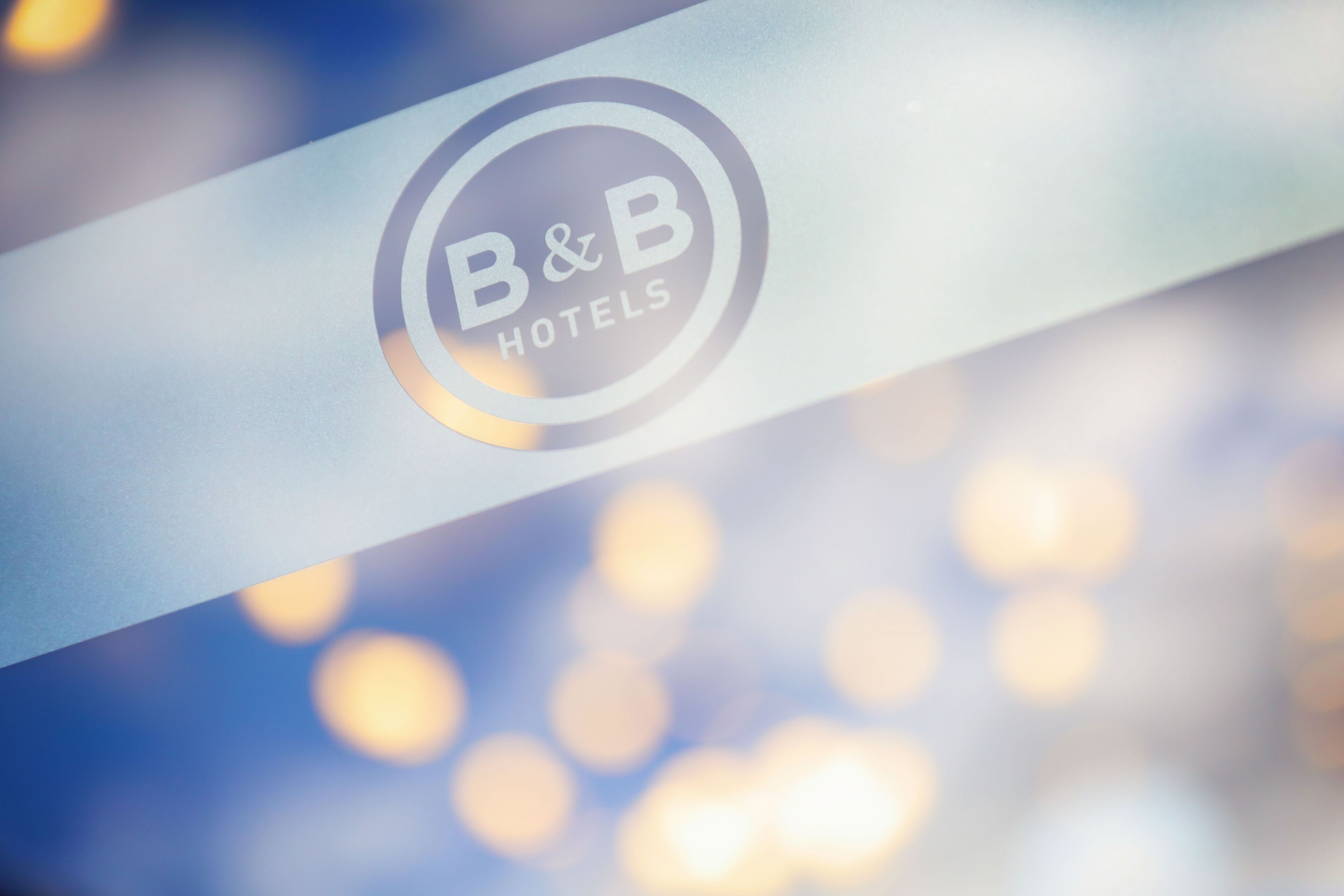 A logo with the text "B&B HOTELS" on a reflective surface.
