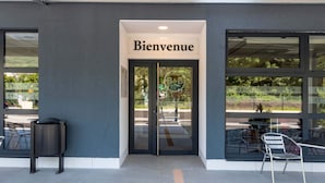 Un escaparate con un letrero que dice "Bienvenue", grandes ventanales y terraza.